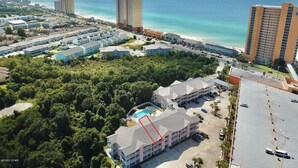 An aerial view of a coastal hotel area with multiple buildings, a beach, and a large body of water. - Peachtree Place By Panhandle Getaways (Panama City Beach)