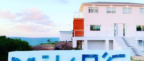 A modern two-story house with a balcony and a sign that reads "MIKA'S".