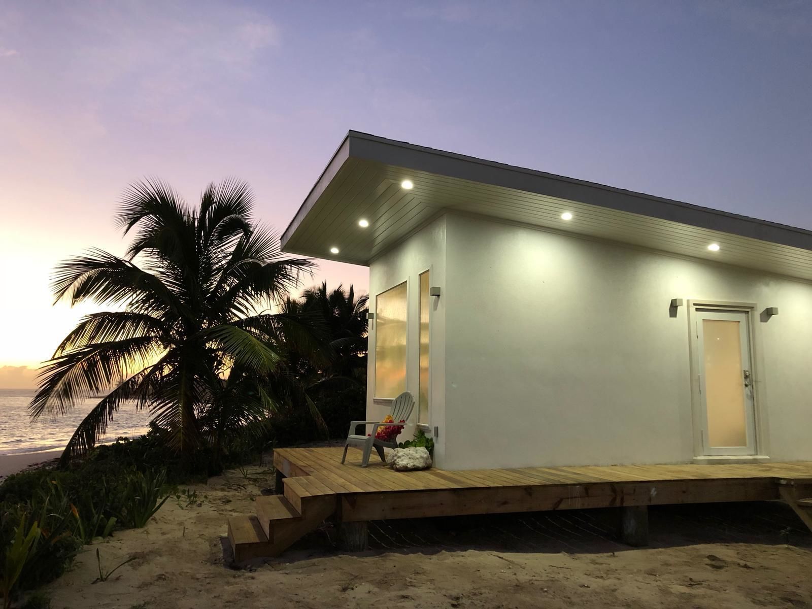 A beachfront property with a wooden deck, a single door, and a small porch area.