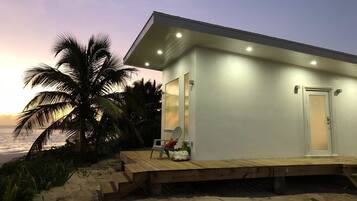 A beachfront property with a wooden deck, a single door, and a small porch area.
