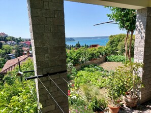 Un balcon donnant sur un jardin et un plan d’eau.
