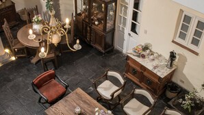 A spacious outdoor patio with a wooden dining table surrounded by chairs, a chandelier, and a cabinet with decorative items. - Casa Cavassa Centro Histórico Cusco (Cusco)