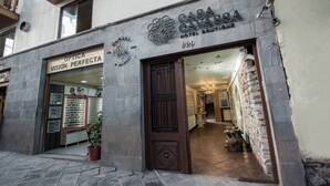 A building with a sign for "Casa Gasa" and "Optica Visión Perfecta" on the ground floor. - Casa Cavassa Centro Histórico Cusco (Cusco)