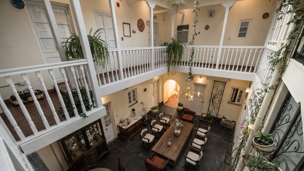 A spacious courtyard with a wooden dining table, multiple chairs, and potted plants. - Casa Cavassa Centro Histórico Cusco (Cusco)
