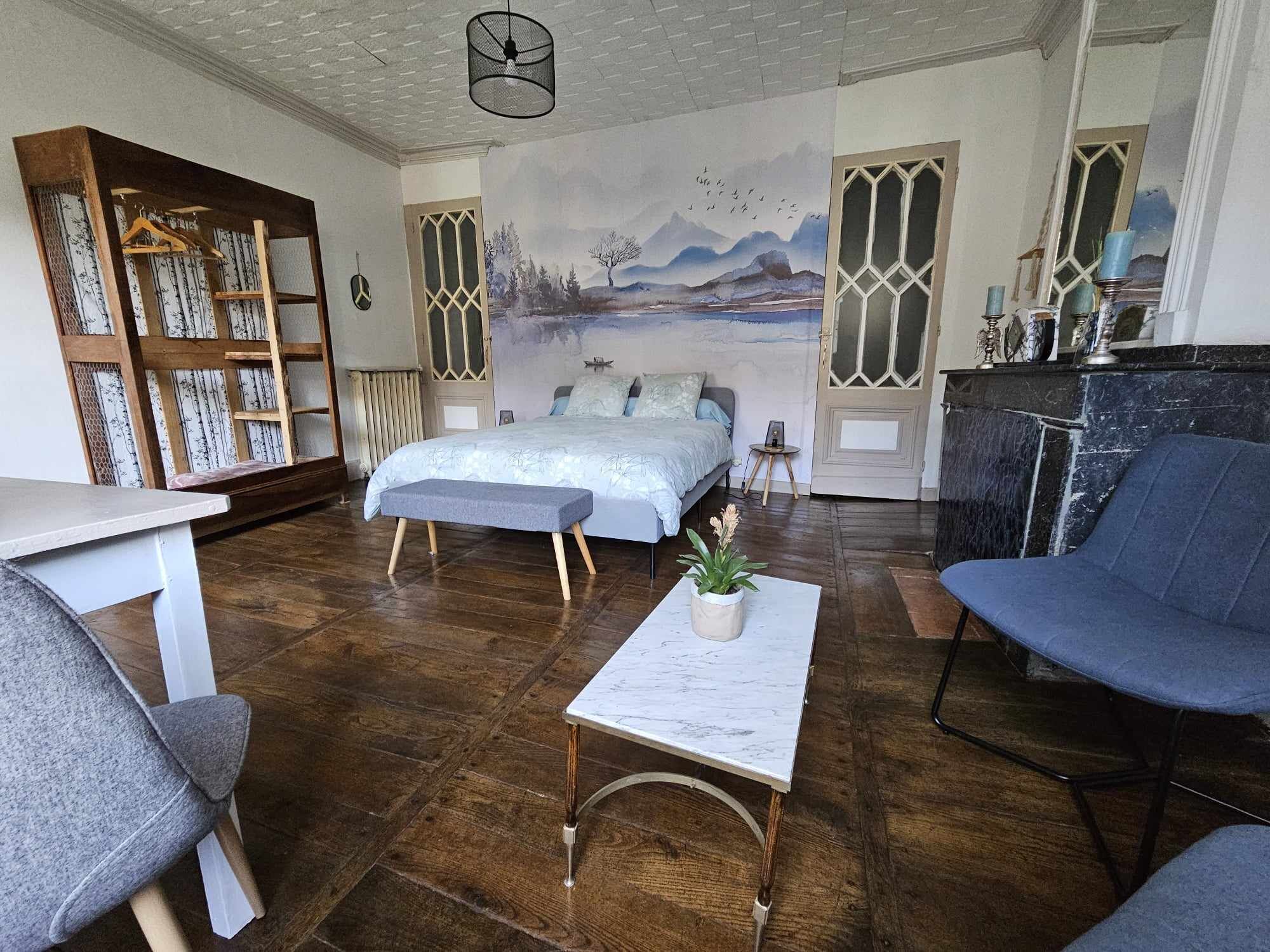 Una habitación acogedora con una cama, un escritorio, una silla y una estantería.