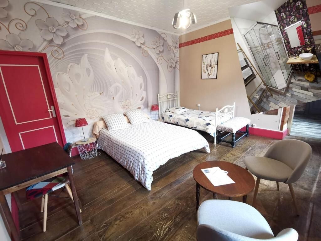 Een slaapkamer met een bed, bureau, stoel en een douchehoek.
