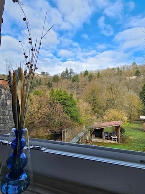 A view from a window overlooking a rural landscape with trees and a small building. - Bastide du Thoré (Labastide-Rouairoux)