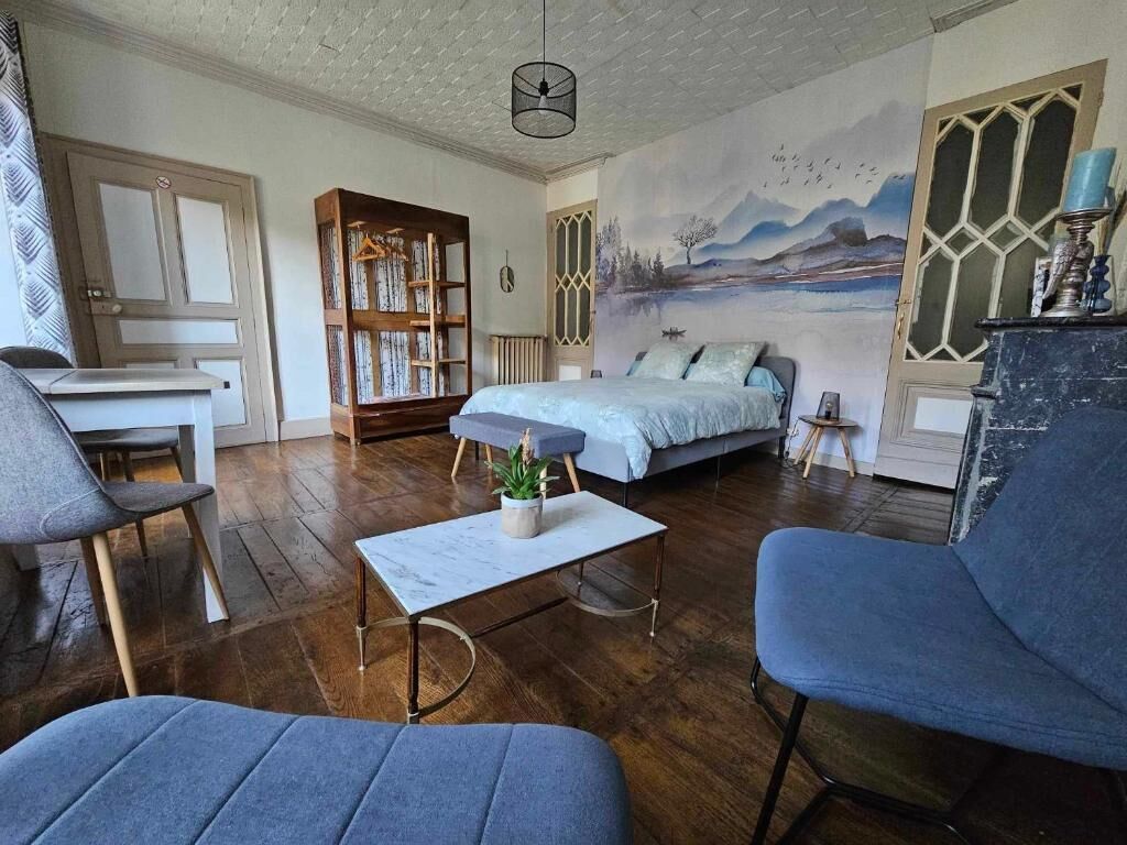 Un salon chaleureux avec un lit, une bibliothèque et une fresque murale.