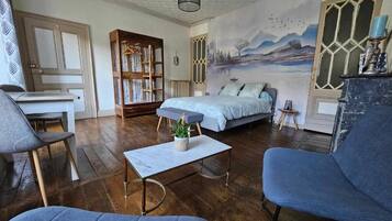 Un salon chaleureux avec un lit, une bibliothèque et une fresque murale.