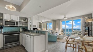 A modern kitchen with white cabinets, a built-in microwave, and a large island. - Majestic Sun Beach Resort by Panhandle Getaways (Miramar Beach)