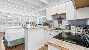A compact, well-lit room with a bed, a small kitchenette, and a window with blinds. - Fontainebleau Terrace by Panhandle Getaways (Panama City Beach)
