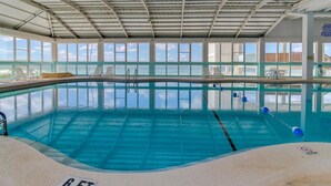 An indoor swimming pool with clear blue water, surrounded by windows and lounge chairs. - Fontainebleau Terrace by Panhandle Getaways (Panama City Beach)
