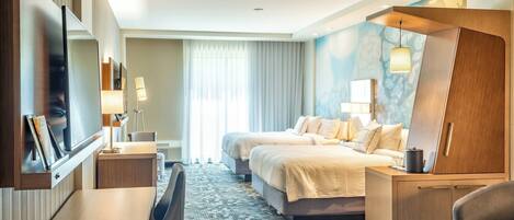 A hotel room with a bed, a desk, a chair, a TV, and a large mirror.
