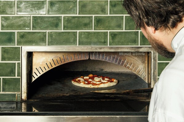 Un four à pizza avec un mur en briques en arrière-plan.