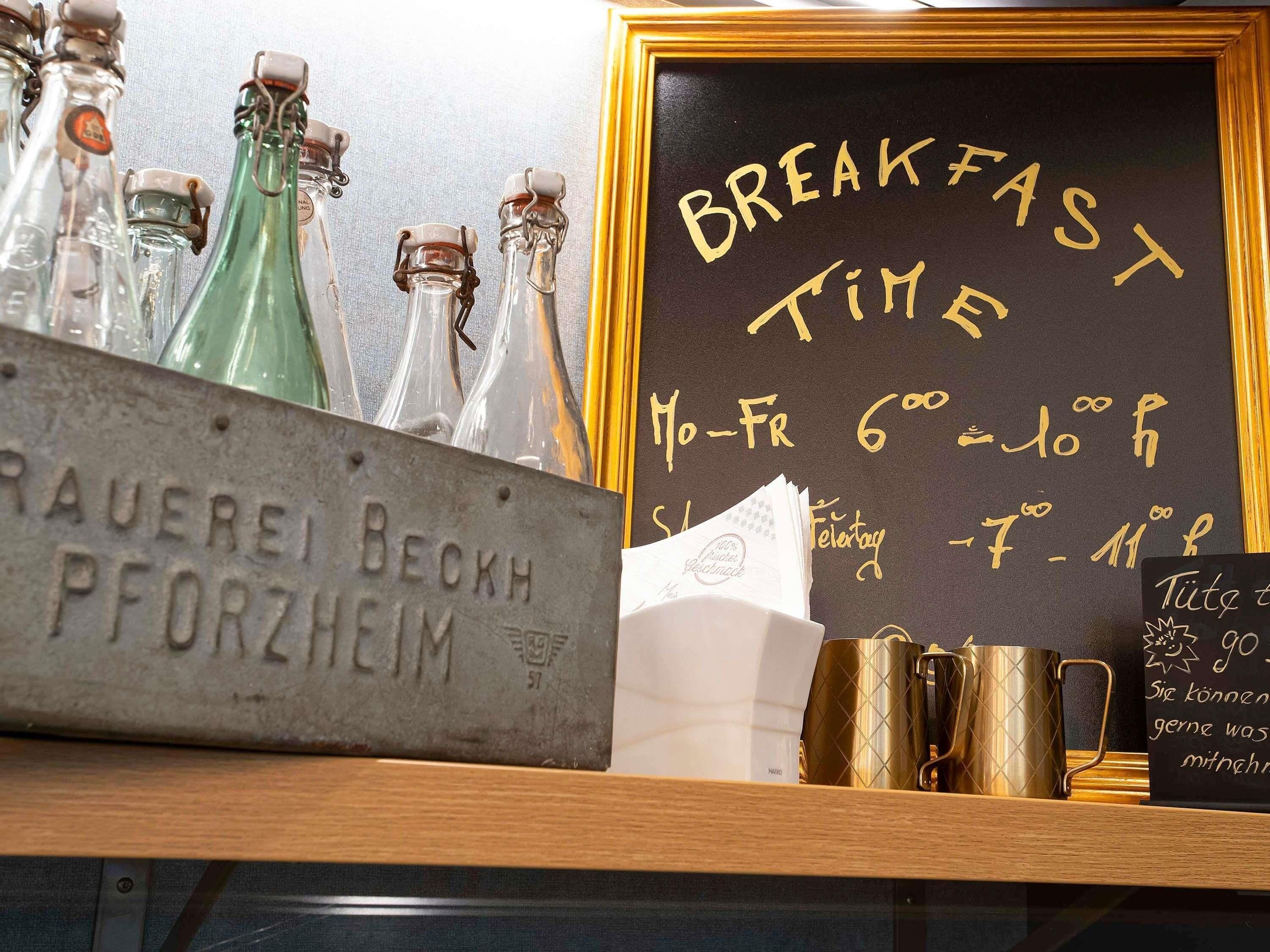 Un cartel anunciando el desayuno, botellas de vidrio antiguas y un letrero de metal.