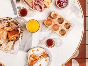A breakfast setting with bread, eggs, ham, and juice on a marble table. - ibis Styles Pforzheim (Pforzheim)