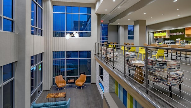 A modern interior with a mezzanine level, seating areas, and a restaurant named "Inspired Table".
