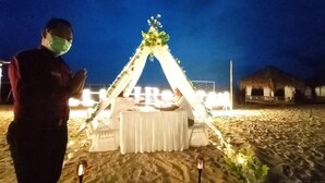 A beachside wedding setup with a canopy and floral decorations. - Hello Bintan Beach Cottages (Bintan)