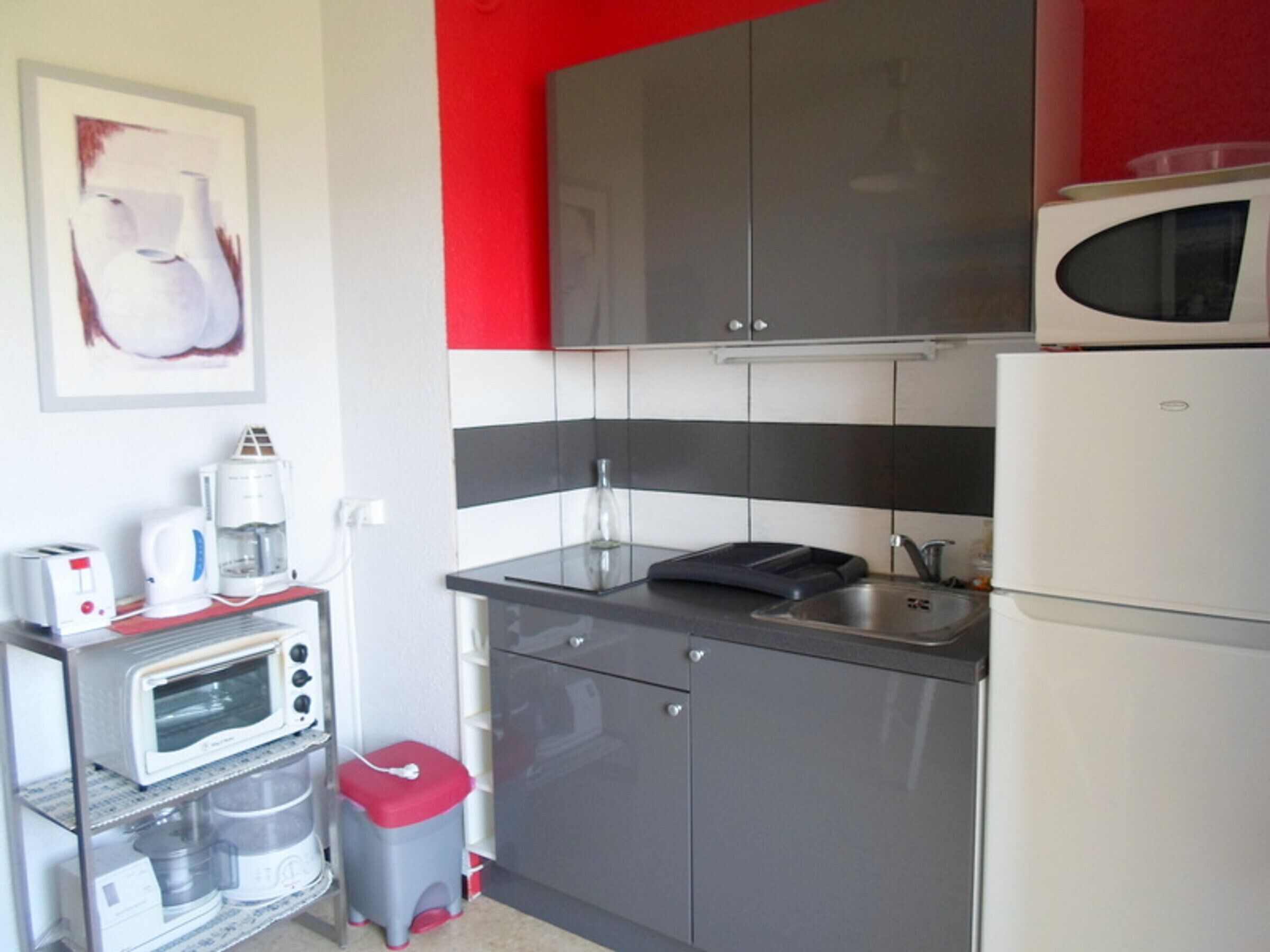 A compact kitchen with a microwave, toaster, and coffee maker on a countertop.