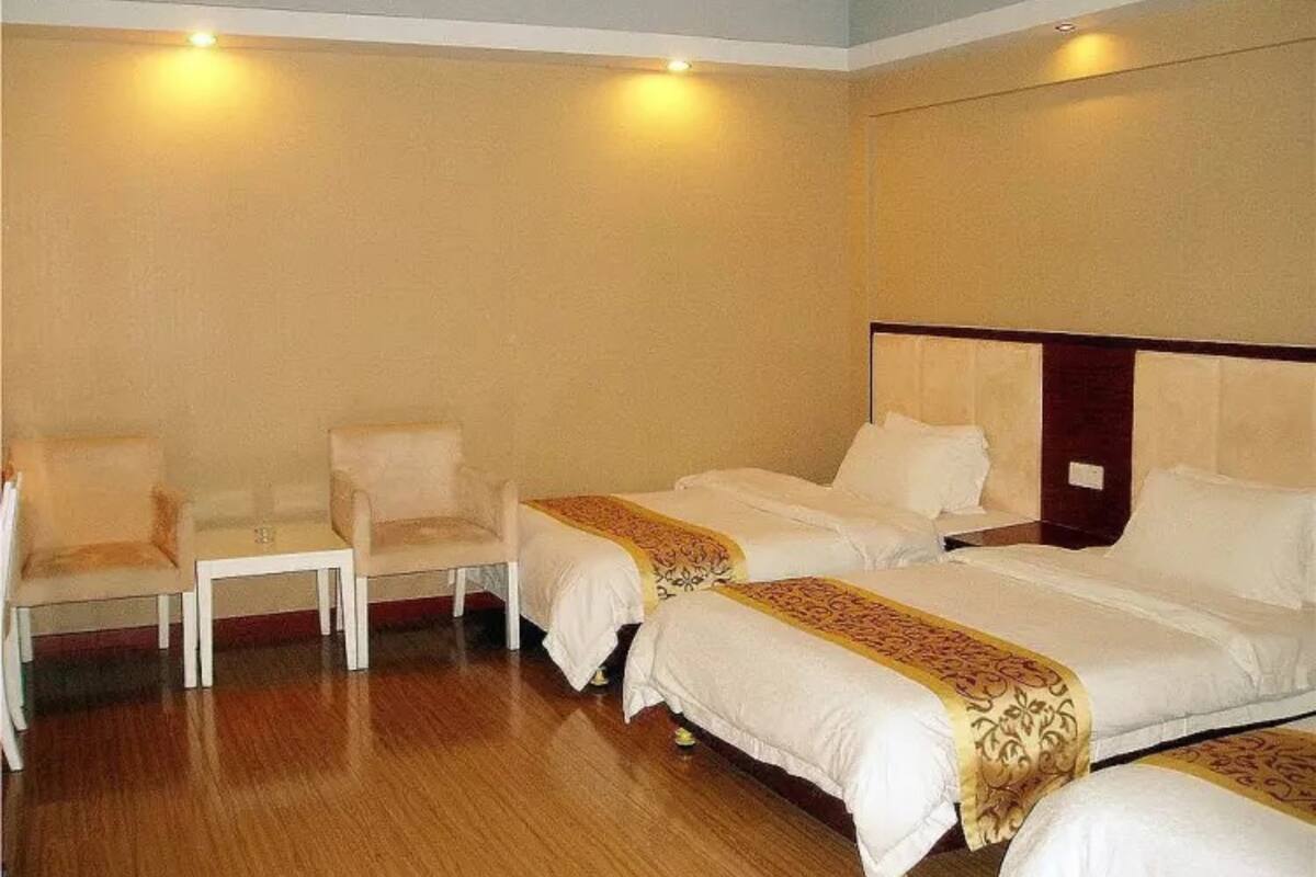 Una habitación de hotel con dos camas, una silla y una mesita.