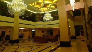 A spacious lobby with high ceilings, chandeliers, and a central seating area. - Junyue Hotel (Zhaoqing)