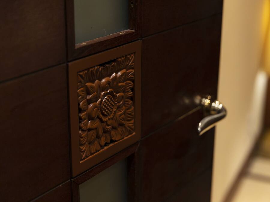 Un gros plan d’une porte ornée d’un panneau décoratif et dotée d’une poignée moderne.