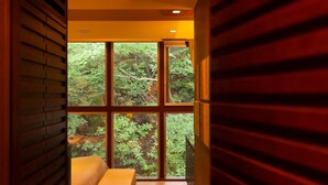 Un dormitorio con un ventanal grande, persianas de madera y una cama.