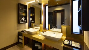 Un baño moderno con dos lavabos, un espejo grande y un estante con art ículos de aseo.