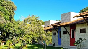 Una casa con puerta roja, ventana azul y fachada de piedra.