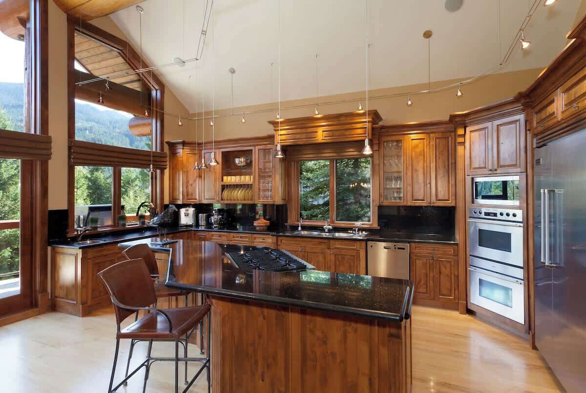 Una cocina amplia con armarios de madera, una isla grande y vistas al exterior.