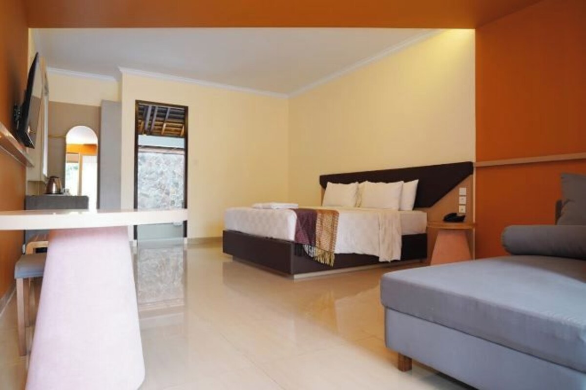 Un dormitorio moderno con cama, sofá y escritorio.