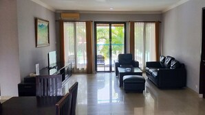 Amplia sala de estar con sofá, sillón y mesa de comedor.