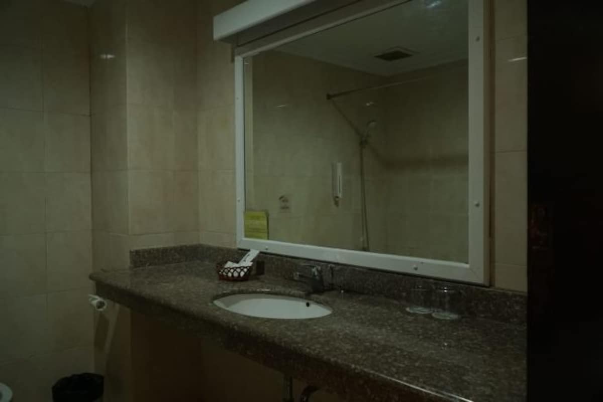 Un baño con lavamanos, espejo y ducha.