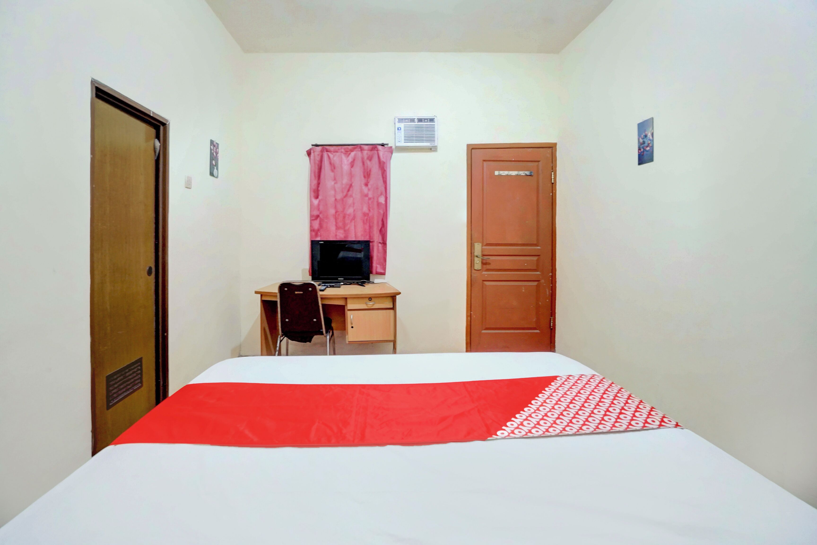 A bedroom with a bed, a desk, a chair, and a computer.