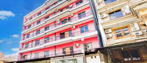 A multi-story building with balconies and air conditioning units.
