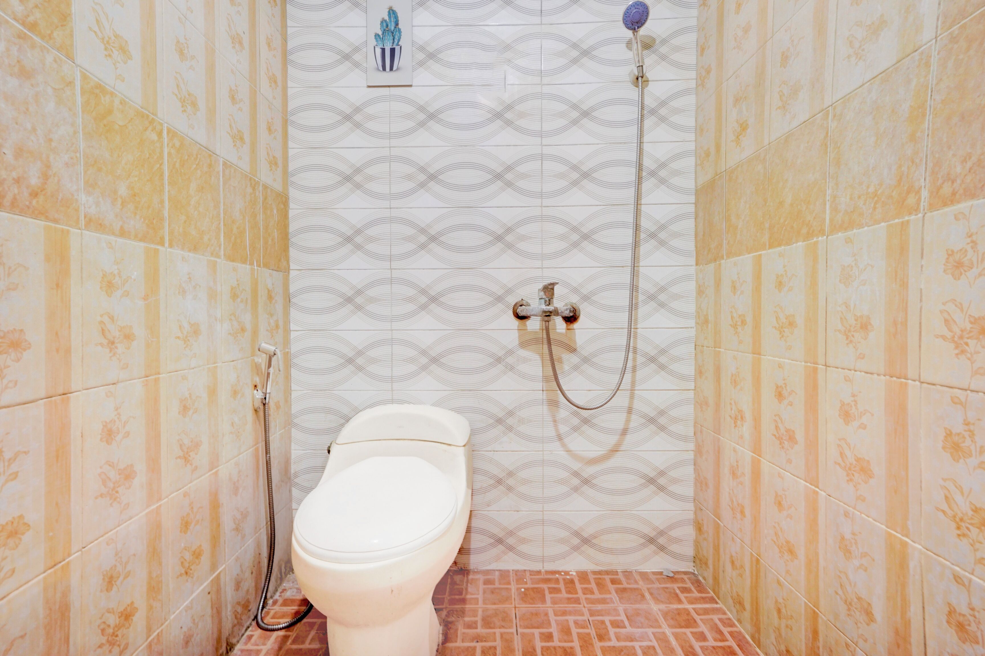 Ein kleines Badezimmer mit Toilette, Dusche und einem Wand-Toilettenpapierhalter.