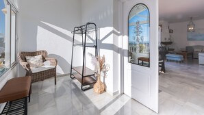 A bright room with a wicker chair, a metal shelf, and a vase with dried flowers. - Villa Panorama – Ocean View Oasis with Private Pool, Mijas Costa (Mijas Costa)