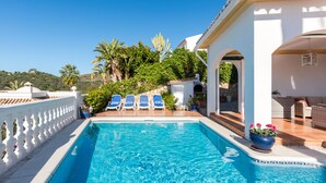 A swimming pool with blue water, surrounded by white columns and blue lounge chairs. - Villa Panorama – Ocean View Oasis with Private Pool, Mijas Costa (Mijas Costa)