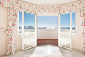 A room with a large sliding glass door leading to a balcony with a clear view of the sea. - Villa Panorama – Ocean View Oasis with Private Pool, Mijas Costa (Mijas Costa)