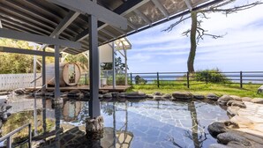 Un espace spa comprenant un jacuzzi, une piscine en pierre et une vue sur la mer.