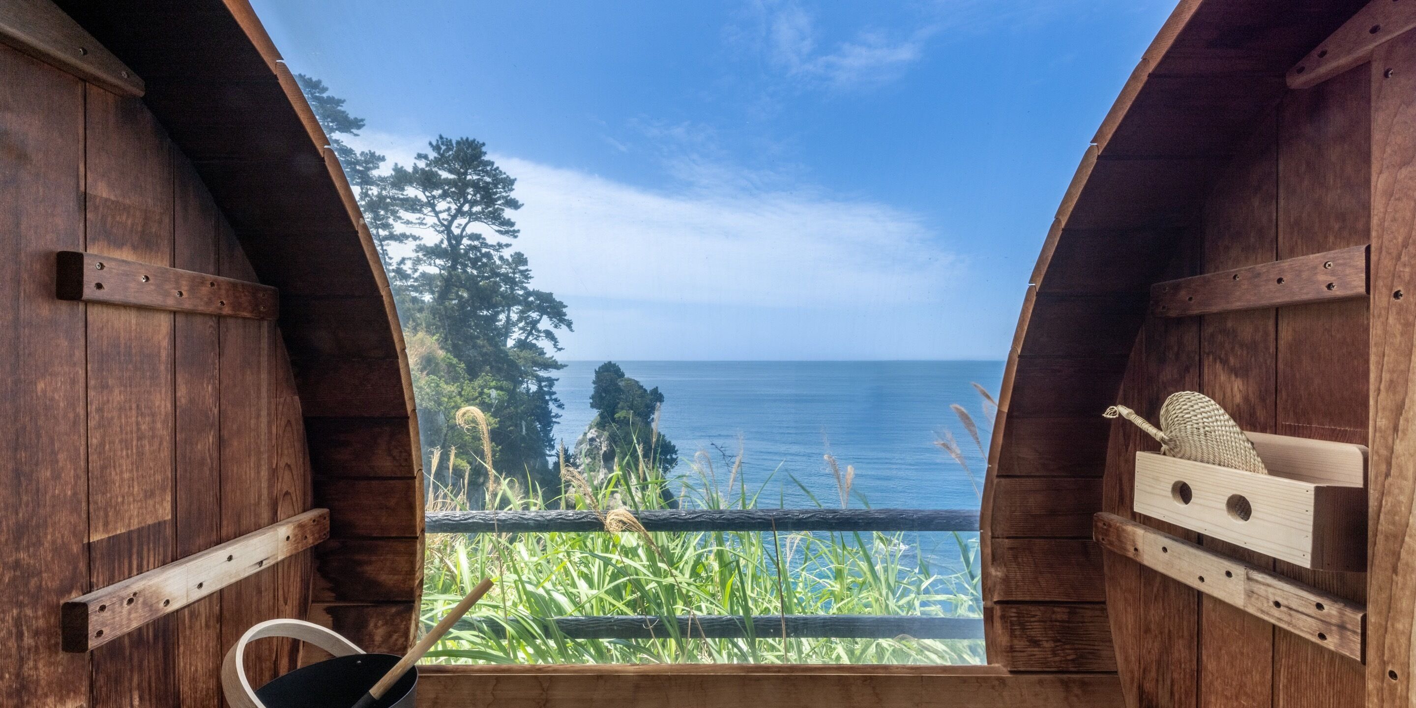 A wooden structure with a view of the sea and greenery.