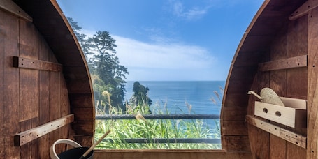 A wooden structure with a view of the sea and greenery.