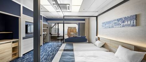 A modern hotel room with a large bed, a desk, and a seating area.