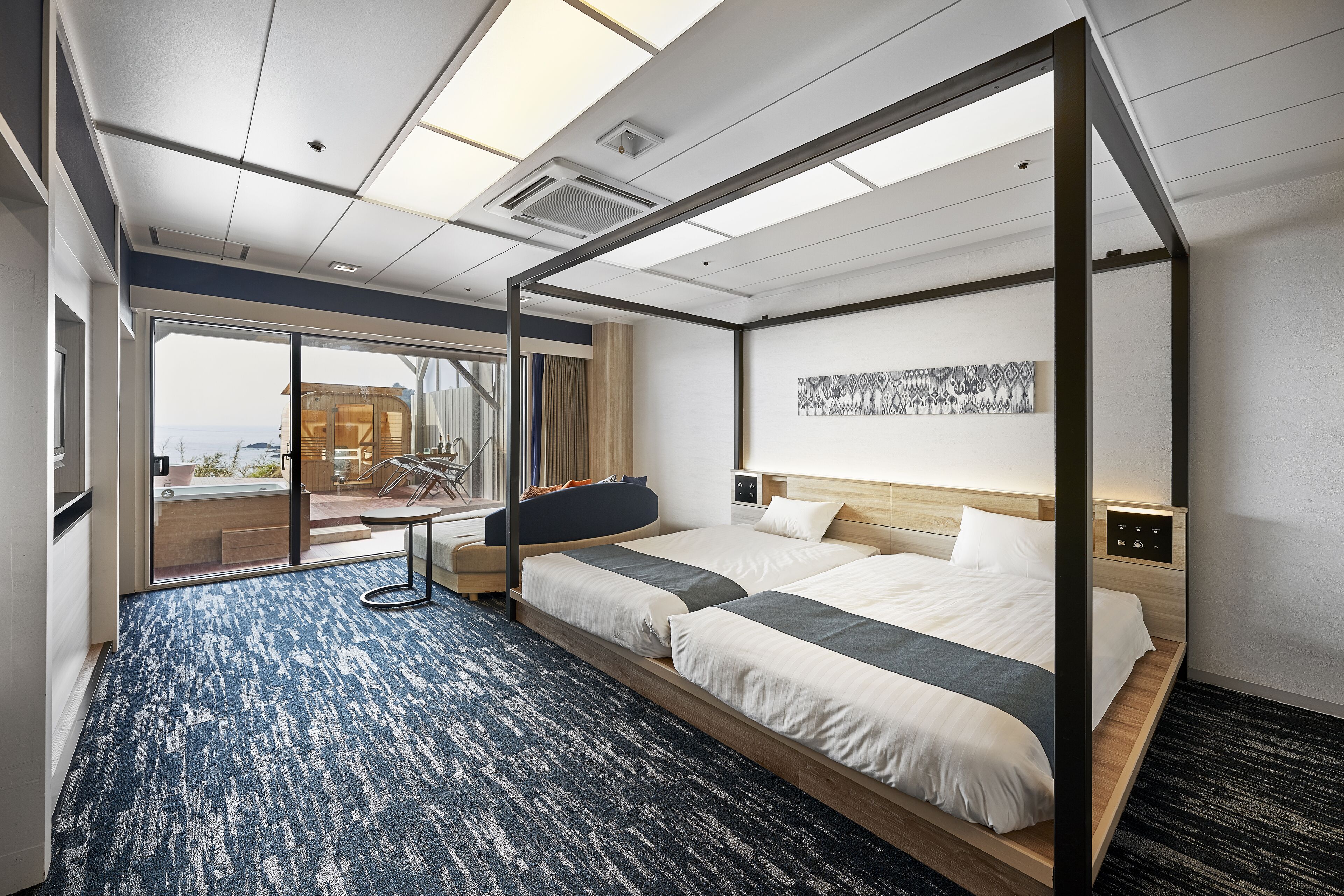 Quarto de hotel moderno com uma cama grande, uma escrivaninha e vista para a cidade.