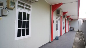 A corridor with air conditioning units, a window, and a tiled floor. - OYO 1007 Alletha Guest House 2 (Balikpapan)