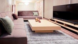 Een moderne woonkamer met een bank, een salontafel en een televisie.
