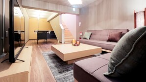 Een moderne woonkamer met een bank, een salontafel en een flatscreen televisie.