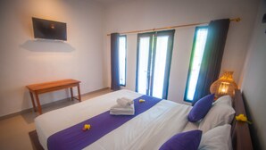Una habitación de hotel con una cama, un banco, un televisor y una ventana con cortinas.
