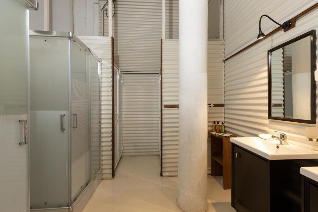 Une salle de bain moderne avec une douche à parois de verre, un lavabo avec un miroir et un porte-serviettes.