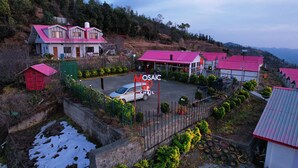 Un hotel con tetto rosso, un'area di parcheggio e un cartello con scritto 'MOSAIC CHAI'.